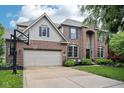 Charming brick two-story home featuring a large driveway and attached two-car garage at 1345 Lewiston Dr, Westfield, IN 46074