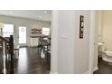 Hallway view showcases wood floors, access to bathroom, and open layout to kitchen at 13616 Whitten N Dr, Fishers, IN 46037