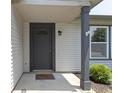 A covered front door with a welcome mat and adjacent window and landscaping at 14255 Holly Berry Cir, Fishers, IN 46038