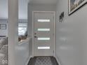 Bright entryway featuring a modern door with frosted glass and a gray accent wall at 1504 Mcclure Rd, Columbus, IN 47201