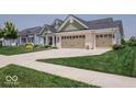 The home has a large three-car garage and a well-maintained lawn and landscaping at 15879 Viking Commander Way, Westfield, IN 46074