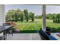 Covered patio offers a peaceful view of the large yard with mature trees and landscaping at 15879 Viking Commander Way, Westfield, IN 46074