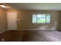 Cozy living room featuring neutral paint, carpeted floors, and ample natural light from a large window at 1749 N Graham Ave, Indianapolis, IN 46218