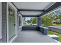 Covered front porch showcasing painted beams, concrete flooring and privacy walls, with a view of the street at 2896 Sutherland Ave, Indianapolis, IN 46205