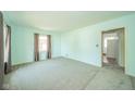Bright living room featuring soft carpet, two windows with drapes, and light blue walls at 2908 Sherman St, Anderson, IN 46016
