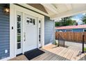 Inviting entryway featuring a white front door with glass panels and a cozy wooden porch at 2928 Mounds Rd, Anderson, IN 46016