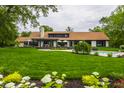 Expansive backyard with lush green lawn, swimming pool, and covered patio offers serene outdoor living at 3549 W 131St St, Carmel, IN 46032