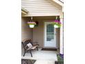 Inviting front porch featuring hanging flower baskets and a cozy bench for relaxing outdoors at 4353 W Parkway Ct, New Palestine, IN 46163