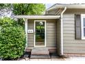 Home exterior featuring the front door, siding, and decorative bushes at 5119 Norwaldo Ave, Indianapolis, IN 46205