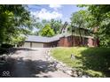 Stately home featuring an extra long driveway, a brick and siding exterior, and mature trees at 5530 Shawnee Trail South Dr, Indianapolis, IN 46220