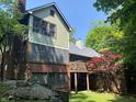 Multi-level home featuring brick and siding with a wooden deck, backyard landscaping, and mature trees at 5530 Shawnee Trail South Dr, Indianapolis, IN 46220