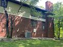 Side view of the home featuring brick, vinyl siding, an air conditioning unit and partial landscaping at 5530 Shawnee Trail South Dr, Indianapolis, IN 46220