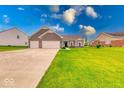 Attractive single-story home featuring a brick facade, attached two-car garage, and green lawn at 59 Manchester Dr, Trafalgar, IN 46181