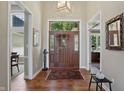 Inviting foyer featuring hardwood floors, a stylish light fixture, and views into adjoining rooms at 5940 Chapmans Trl, Carmel, IN 46033