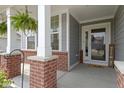 Inviting front porch with classic columns, brick accents, and a welcoming 'hello' door mat at 6107 Flagler Ln, Brownsburg, IN 46112