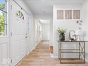 Bright entryway featuring hardwood floors, white walls, decorative art, and a modern console table at 6133 Buttonwood Dr, Noblesville, IN 46062