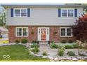 Close up of the home's welcoming front entrance with red brick, vinyl siding, and well-maintained landscaping at 6133 Buttonwood Dr, Noblesville, IN 46062