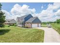 Beautiful two-story home boasts a three-car garage and a long driveway on a well-maintained lawn at 6702 W Willow Grove Dr, New Palestine, IN 46163