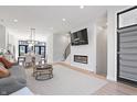 Open-concept living space with modern fireplace, TV, dining area, and large windows at 711 E 16Th St, Indianapolis, IN 46202