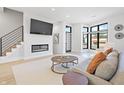 Bright living room showcasing a modern fireplace, mounted TV, sleek staircase and hardwood floors at 711 E 16Th St, Indianapolis, IN 46202