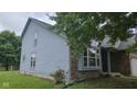 Home exterior featuring light blue siding, brick facade, and a landscaped yard at 7168 Camwell Dr, Indianapolis, IN 46268