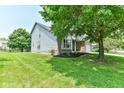 Lovely landscaped front yard featuring a vibrant green lawn and mature shade trees at 7168 Camwell Dr, Indianapolis, IN 46268