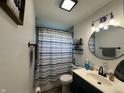 Bathroom featuring modern fixtures, including a round mirror, stylish vanity, and patterned shower curtain at 7346 E Buddy Ln, Camby, IN 46113
