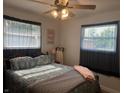 Cozy bedroom with a patterned quilt, ceiling fan, and soft natural light streaming through the windows at 7346 E Buddy Ln, Camby, IN 46113