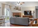 Bright living room featuring a brick fireplace, hardwood floors, and sliding door access to the yard at 7743 Waterwood Dr, Indianapolis, IN 46214