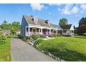 Two-story home with a covered front porch, landscaped yard and private driveway at 808 N Layman Ave, Indianapolis, IN 46219