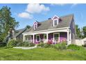 Charming two-story home boasts a welcoming front porch and beautiful lawn in a suburban neighborhood at 808 N Layman Ave, Indianapolis, IN 46219