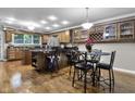 Open kitchen with hardwood floors, granite countertops, stainless steel appliances, and a breakfast bar at 8310 Fall Creek Rd, Indianapolis, IN 46256
