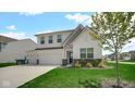 Charming two-story home featuring a three-car garage, well-manicured lawn, and stylish architectural details at 8690 Lester Pl, Pendleton, IN 46064