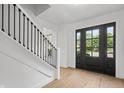 Bright foyer features hardwood floors, a staircase with black iron spindles, and a front door with window pane accents at 9205 Selkirk Ct, Indianapolis, IN 46260