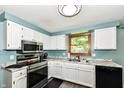 Well lit kitchen with white cabinetry, marble countertops, and stainless steel appliances at 9402 Thornwood Dr, Indianapolis, IN 46250