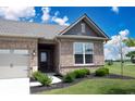 A welcoming entryway with a black front door, brick facade, and green shrubbery at 9671 Holborn Ave, McCordsville, IN 46055