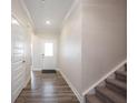 Inviting hallway with hardwood floors, white trim, and a view of the front door at 9671 Holborn Ave, McCordsville, IN 46055