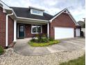 Close up of the home's entry way with a well-manicured garden in front of the two-car garage at 1019 White Oak Dr, Plainfield, IN 46168