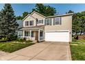 Charming two-story home with blue shutters, a well-manicured lawn, and an attached two-car garage at 10216 Hatherley Way, Fishers, IN 46037