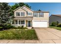 Charming two-story home with blue shutters, a well-manicured lawn, and an attached two-car garage at 10216 Hatherley Way, Fishers, IN 46037