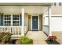 Inviting front porch with white columns, decorative railing, and a blue front door at 10216 Hatherley Way, Fishers, IN 46037