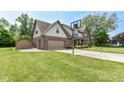 Side view of two-story home featuring a well maintained lawn and a basketball hoop at 1031 W Morning Walk Dr, Greenfield, IN 46140