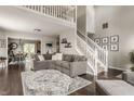 Spacious living room with hardwood floors, a large sectional sofa, and a view of the upper level at 10380 Sand Creek Blvd, Fishers, IN 46037