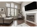 Bright living room with large windows, fireplace, hardwood floors, and comfortable lounge seating at 10380 Sand Creek Blvd, Fishers, IN 46037