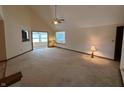 A spacious living room with vaulted ceilings, carpet flooring, and access to the kitchen and sunroom at 10976 Mt Vernon N Trl, Indianapolis, IN 46229