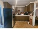 Well-lit kitchen with stainless steel refrigerator, ample counter space, and wooden cabinets at 1102 S Dequincy St, Indianapolis, IN 46203