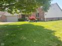 Beautiful front yard featuring a large tree, manicured lawn, and decorative landscaping, enhancing the home's curb appeal at 1165 Tewksbury Ct, Mooresville, IN 46158