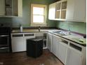 Functional kitchen with white cabinets, sink, and a window offering natural light at 121 School St, Greenfield, IN 46140