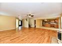 Spacious living room with hardwood floors, neutral walls, ceiling fan, and adjacent kitchen at 1252 Jasmine Dr, Greenfield, IN 46140