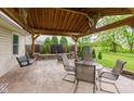 Relax on the covered patio with outdoor furniture and a swing, all in a private and landscaped backyard at 12535 Old Pond Rd, Noblesville, IN 46060